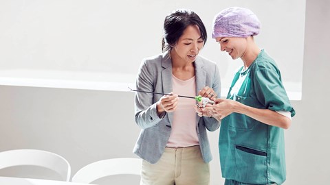 female supplier demonstrating a surgical instrument to a female healthcare professional